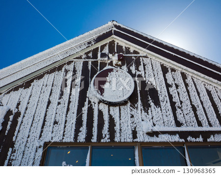 山頂餐廳的外牆被霜凍覆蓋，藍天映襯（長野縣山之內町，橫手山） 130968365