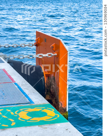 Protective board and mooring rope at the pier by the sea 130969084