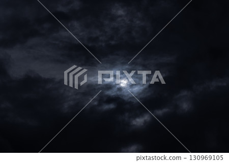 A dramatic depiction of a night sky filled with dark stormy clouds 130969105