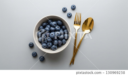 Blueberries in White Bowl with Golden Cutlery Blueberries in White Bowl with Golden Cutlery 130969238