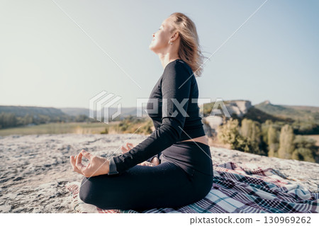 Woman Meditating on a Mountaintop Woman Meditating on a Mountaintop 130969262