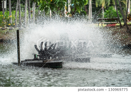 rotating water oxygen generator in park creating droplets, eco-friendly aeration device in pond producing dynamic water splashes, Lumpini park, Bangkok 130969775