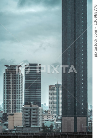 landscape of futuristic dystopia city with gloomy metropolis skyline with skyscrapers, bleak cyberpunk cityscape featuring dark towering structures 130969776