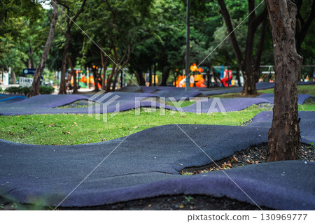 cushioned path for kids cycling or skating in park, soft track for children riding scooters or bikes and bicycle in safe playground area 130969777