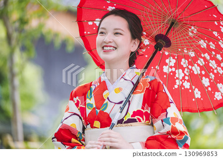 A young woman in a kimono holding a Japanese umbrella A young woman in a kimono holding a Japanese umbrella 130969853