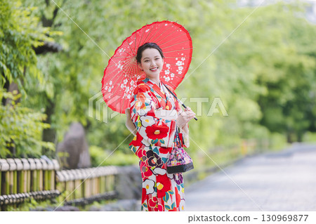 A woman in a kimono sightseeing with a Japanese umbrella 130969877