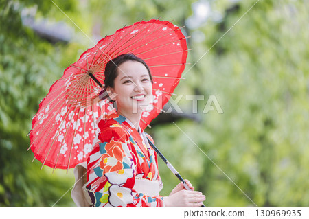 A young woman in a kimono holding a Japanese umbrella 130969935