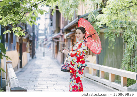 一個穿著和服的年輕女子拿著一把日本雨傘 130969959