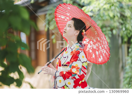 A young woman in a kimono holding a Japanese umbrella 130969960