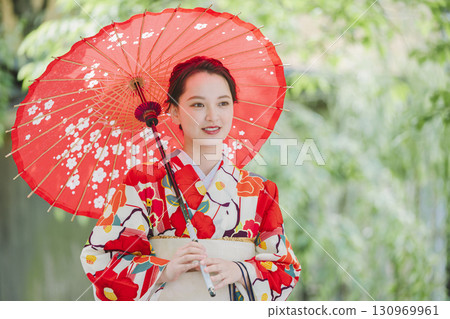 A young woman in a kimono holding a Japanese umbrella 130969961