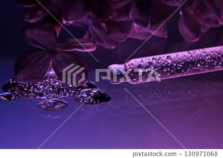 Cosmetic pipette with serum and lilac flowers. 130971068
