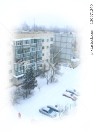 View from frozen window on snowy winter in town yard. Cars parked in winter city. View from frozen window on snowy winter in town yard. Cars parked in winter city. 130971240