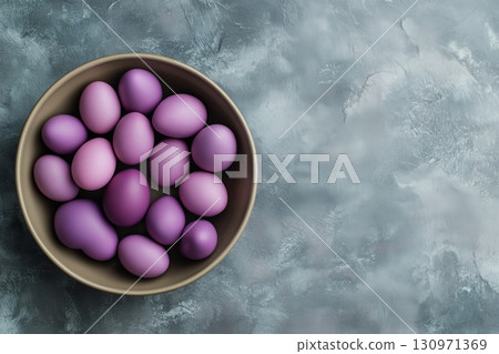 Decorative Purple Eggs Arranged in a Bowl on a Grey Background 130971369