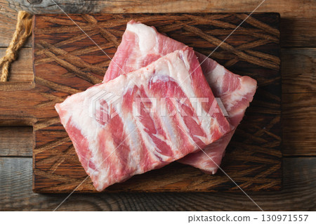 Raw pork ribs with spices, salt and rosemary on dark wooden background 130971557
