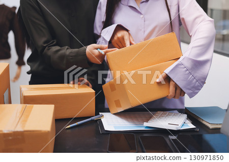 Portrait of Starting small businesses SME owners, two Asian woman check online orders Selling products working with boxs freelance work at home office, sme business online small medium enterprise 130971850