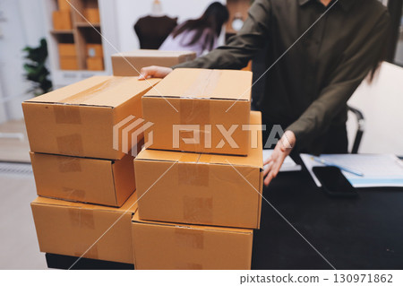 Portrait of Starting small businesses SME owners, two Asian woman check online orders Selling products working with boxs freelance work at home office, sme business online small medium enterprise 130971862