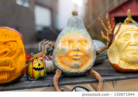 Carved pumpkins with expressive faces create imaginative Halloween decorations. Artistic designs range from spooky to humorous, turning seasonal vegetables into festive sculptures Carved pumpkins with expressive faces create imaginative Halloween decorations. Artistic designs range from spooky to humorous, turning seasonal vegetables into festive sculptures 130971944