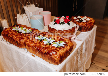 Traditional Slavic wedding bread display with flowers and gift boxes on elegant table 130972092
