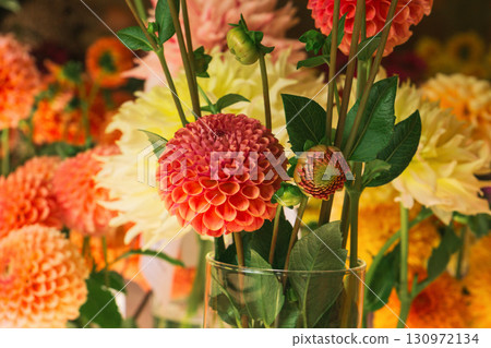 Blooming orange dahlias create a stunning centerpiece for bridal and thanksgiving celebrations 130972134