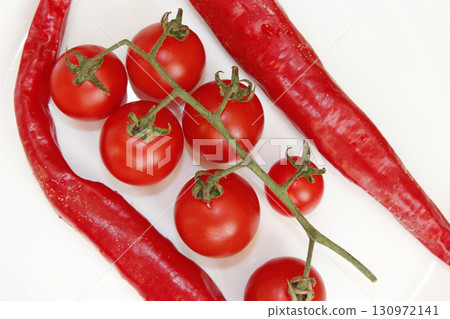 cherry tomatoes and pods of chili peppers isolated 130972141