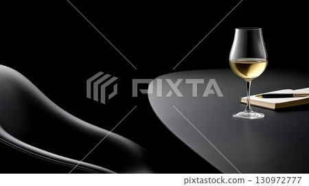 Elegant glass of white wine on a sleek black table with a notebook 130972777