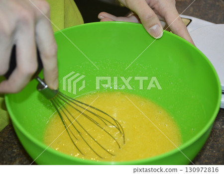 female hands with a whisk mix ingredients for baking dessert female hands with a whisk mix ingredients for baking dessert 130972816