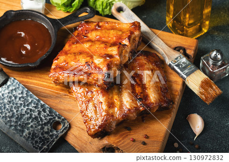 Spicy hot grilled spare ribs from a summer BBQ served with a hot chili pepper and fresh tomatoes 130972832