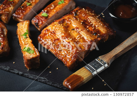 Barbecue pork spare ribs with hot honey chili marinade on black background Barbecue pork spare ribs with hot honey chili marinade on black background 130972857