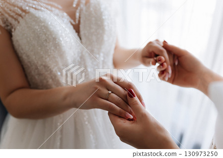 Bride holding hands with mother in emotional moment before wedding ceremony, close up Bride holding hands with mother in emotional moment before wedding ceremony, close up 130973250