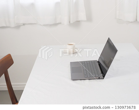 Laptop and cafe au lait on a white table Laptop and cafe au lait on a white table 130973678
