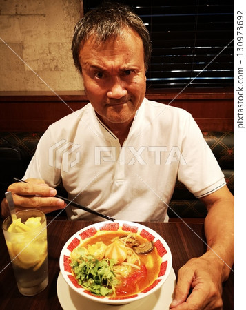 Senior man eating malatang 130973692