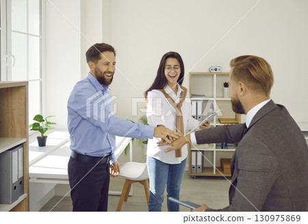 Beautiful and happy young people put their palms on each other as sign of approval. 130975869