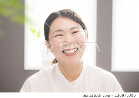 A woman in her late 40s smiling despite menopause, looking at the camera, close-up A woman in her late 40s smiling despite menopause, looking at the camera, close-up 130976390