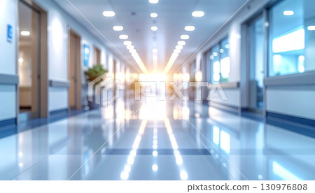 Bright interior of a modern business building with empty corridor, floor-to-ceiling glass walls, and natural light flooding the hallway 130976808