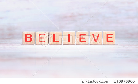 The concept word BELIEVE is made of wooden cubes on a light background. Business believe concept. Copy space. 130976900