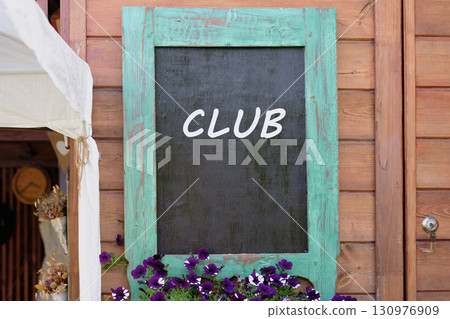 Business and Entrepreneurship. Copy space. Text Business Club written on Charming wooden wall with a turquoise-framed chalkboard Business and Entrepreneurship. Copy space. Text Business Club written on Charming wooden wall with a turquoise-framed chalkboard 130976909