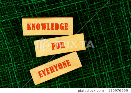 Education Concept text KNOWLEDGE FOR EVERYONE made of wooden blocks on fabric background, top view 130976969