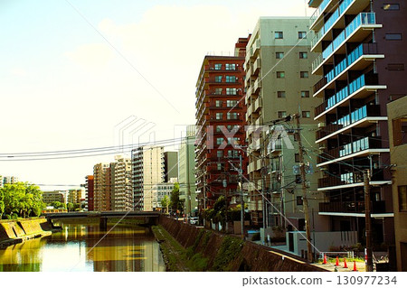 鹿兒島中央站附近的小月川沿岸的公寓大樓和高見橋 130977234