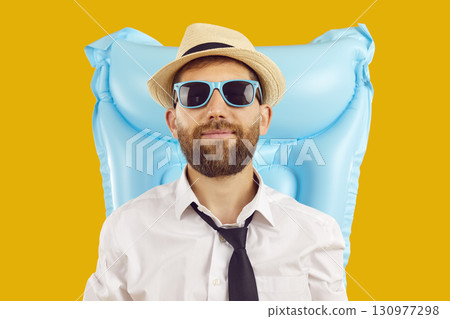 Man portrait in office clothes with inflatable mattress on studio yellow background. 130977298