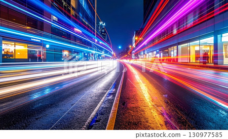 Vibrant urban lights blur with the motion of cars on a busy city highway at night 130977585