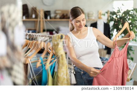 Adult woman choosing jumpsuit in clothing store Adult woman choosing jumpsuit in clothing store 130978014