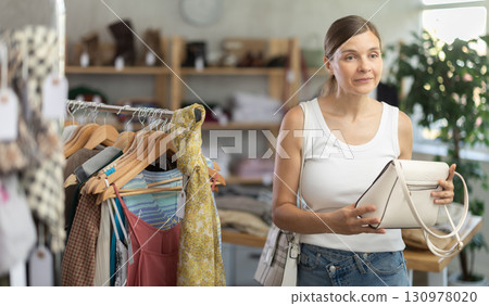 Adult women choosing handbag in store 130978020