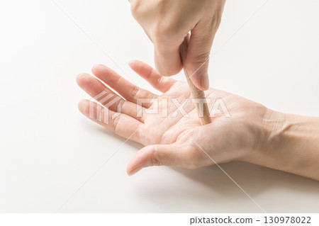Pressing acupressure points on the hands with an acupressure stick - stock photo Pressing acupressure points on the hands with an acupressure stick - stock photo 130978022