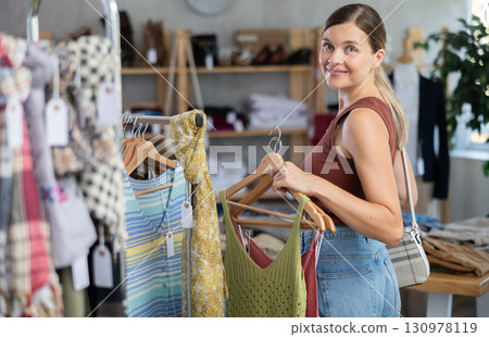Adult woman choosing summer clothes in store Adult woman choosing summer clothes in store 130978119