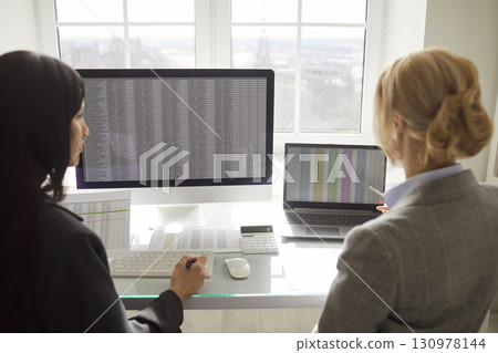 Business owners women, individual female entrepreneur serious businesswomen stock market data check 130978144