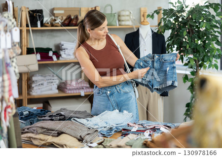 Adult woman choosing denim shorts in store 130978166