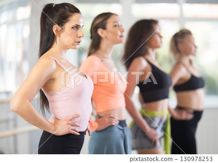 Woman rehearsing graceful walk during stiletto dance group class 130978253