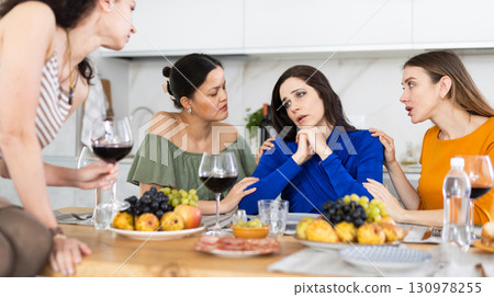 Attentive besties comforting upset brunette during home gathering 130978255