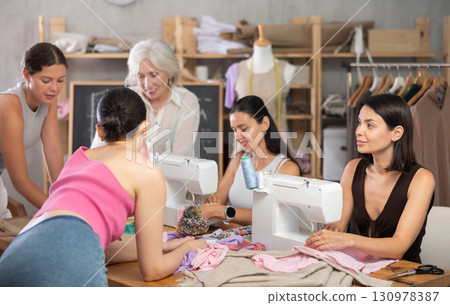 Group of women sew and draw pattern at sewing workshop Group of women sew and draw pattern at sewing workshop 130978387