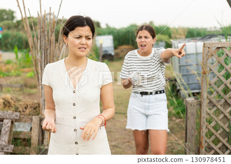 Farm owner scolding female worker during harvest. Farm owner scolding female worker during harvest. 130978451